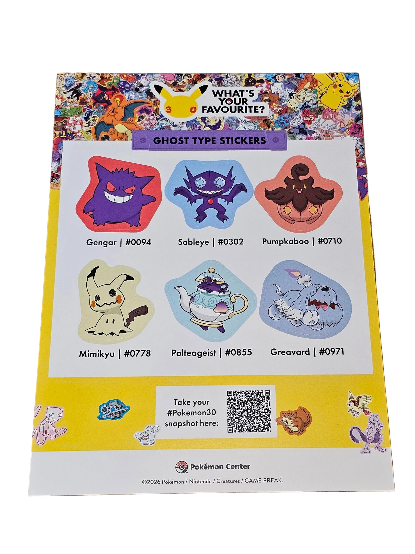 Sheet of ghost-type Pokémon stickers on a wooden surface