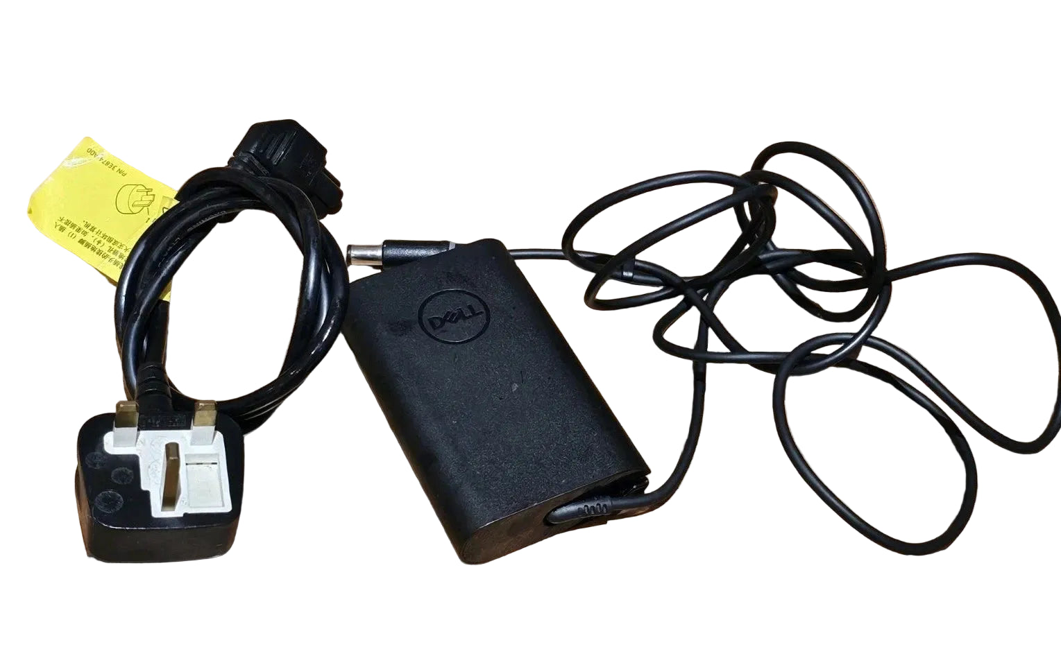 Black Dell power adapter with cable on a wooden surface